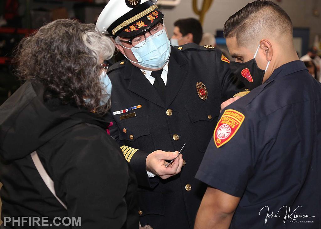 FF Oman Acevedo and his mother receiving badge from Chief Smith