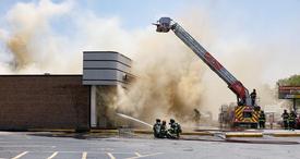 Firefighters in front of building battling the fire