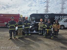 Students pose after using Jaws of Life to perform a simulated victim extrication from a crashed auto